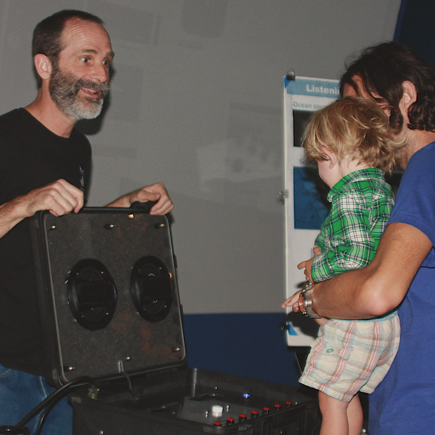 Our featured speaker, Dr. John Ryan, Senior Research Specialist at MBARI, playing blue whale sounds on a speaker for a parent and child